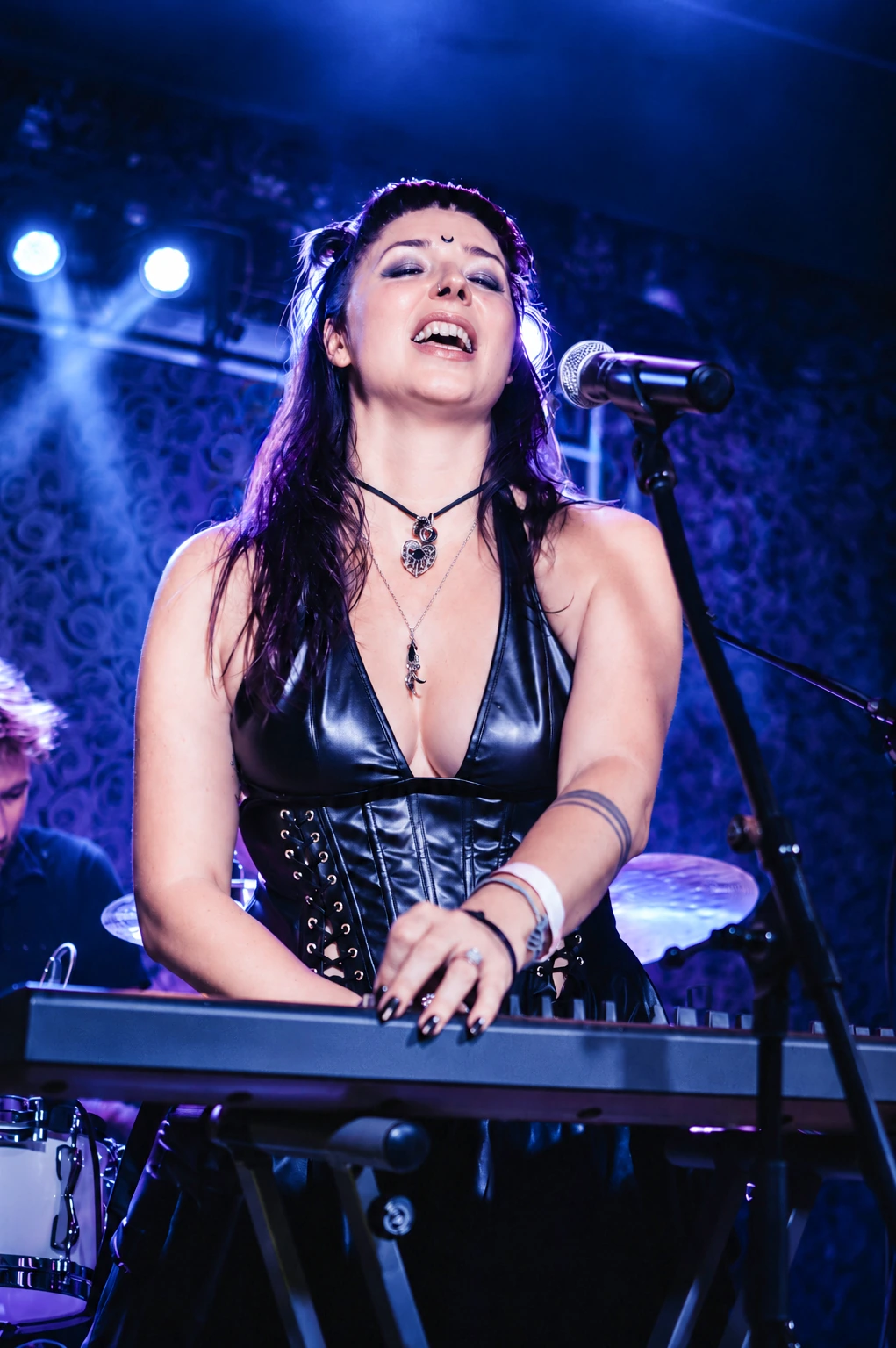 Rika Bender live an ihrem Synthesizer im blauen Bühnenlicht